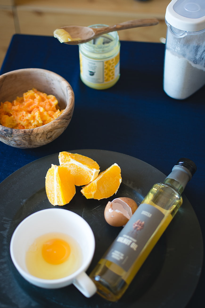 Ingredients for baking orange cake on dark table