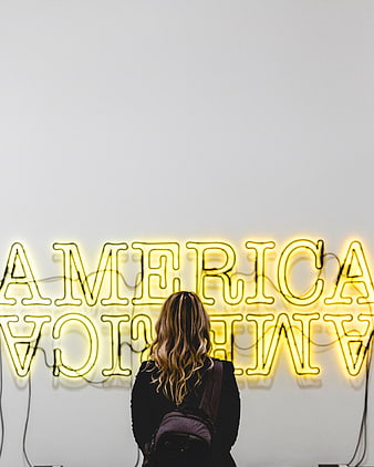 Woman Viewing Yellow Neon America Sign