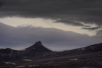 Dramatic mountain peak under dark storm clouds