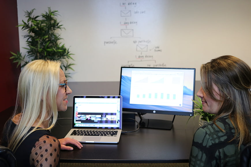 Two Women Discussing Website Analytics in Modern Office