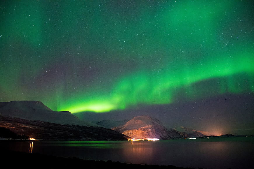 Vibrant Green Aurora Borealis Over Snowy Mountains and Lake