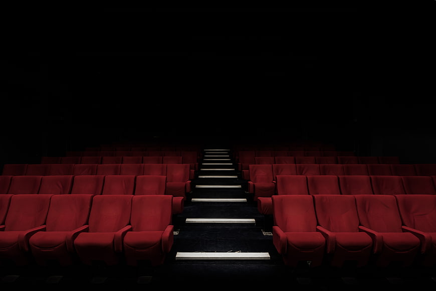 Dark Empty Cinema Auditorium with Red Seats