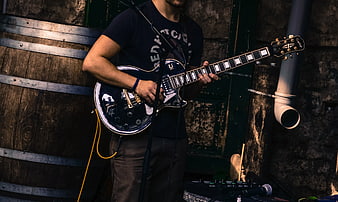 Musician Playing Black Electric Guitar on Stage