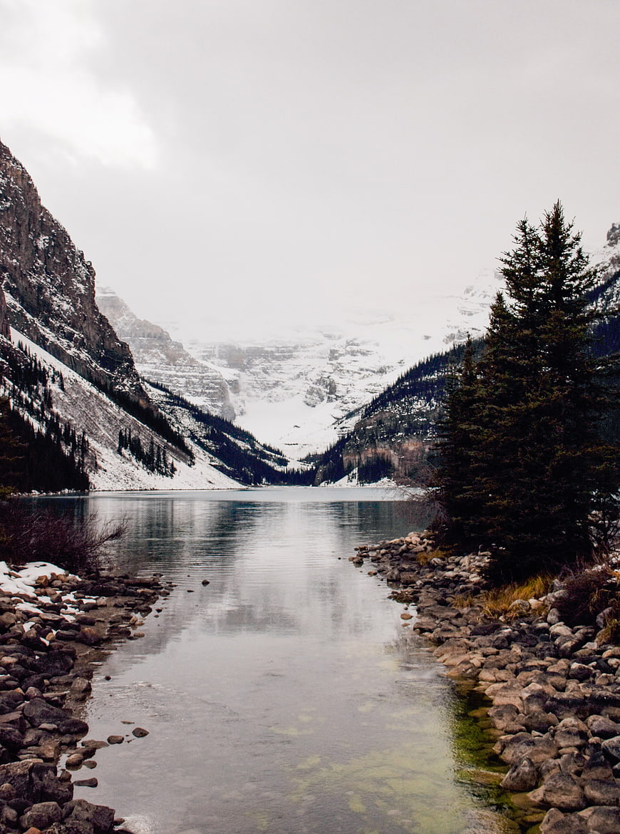 Serene Snow-Capped Mountain Lake with Rocky Shoreline