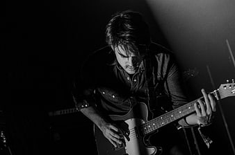 Black and white portrait of male guitarist playing electric guitar