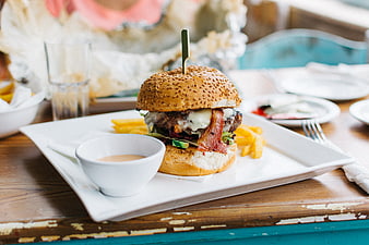 Delicious Bacon Cheeseburger with Fries on White Plate