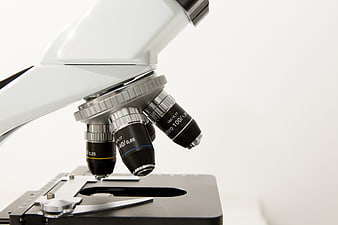 Close-up of microscope objective lenses on white background