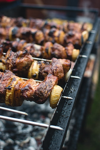 Close-up of grilled meat and onion skewers on a barbecue