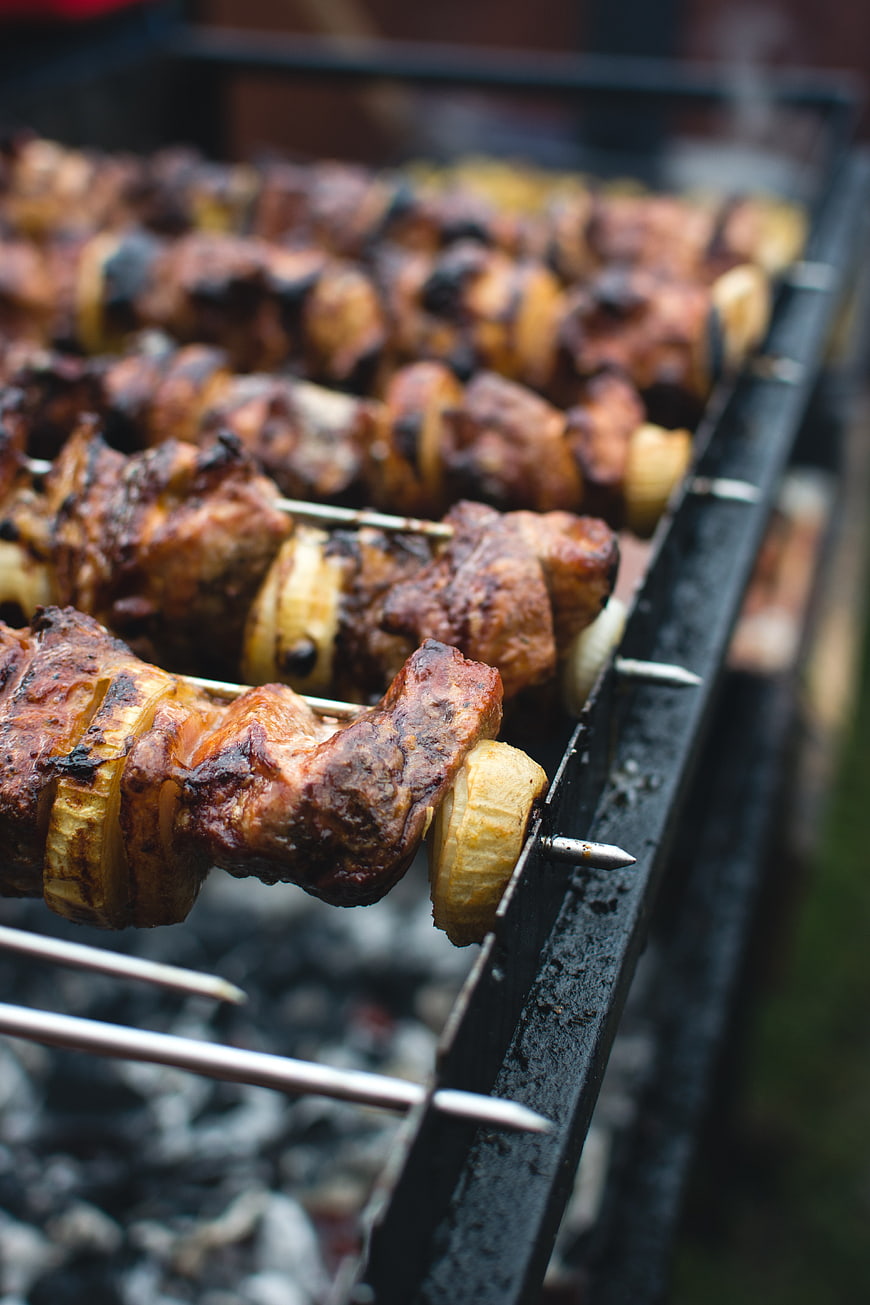 Close-up of grilled meat and onion skewers on a barbecue