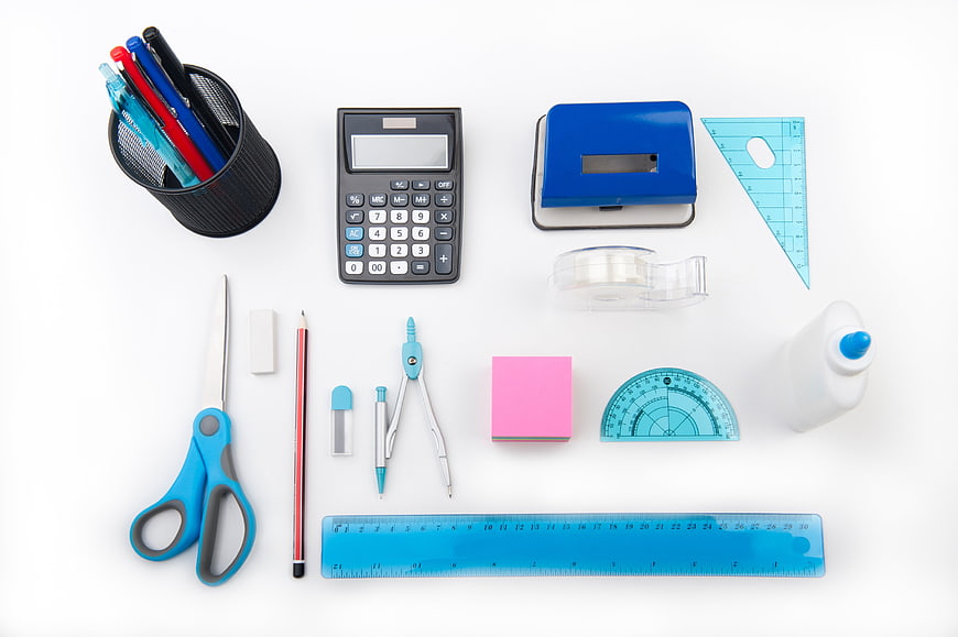 Flat lay of colorful school supplies on white background