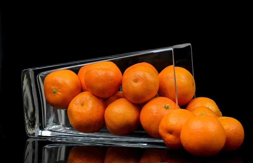 Fresh Mandarins in Glass Bowl on Black Background