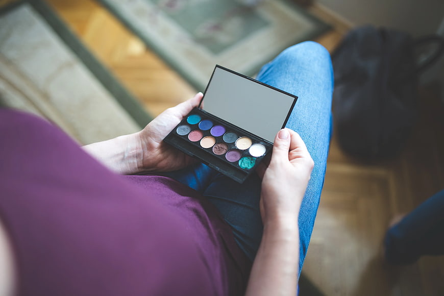 Woman holding colorful eyeshadow palette