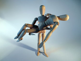 Wooden Articulated Puppet Carrying Another Figure on Light Background