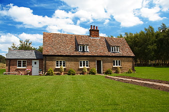 Traditional Brick Cottage With Garden And Blue Sky