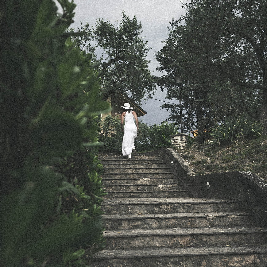 Woman in White Dress Walking Up Stone Steps in Nature