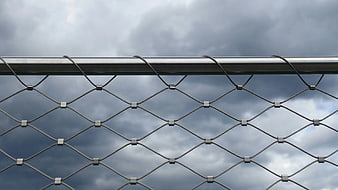 Metal Cable Mesh Fence Against Cloudy Sky