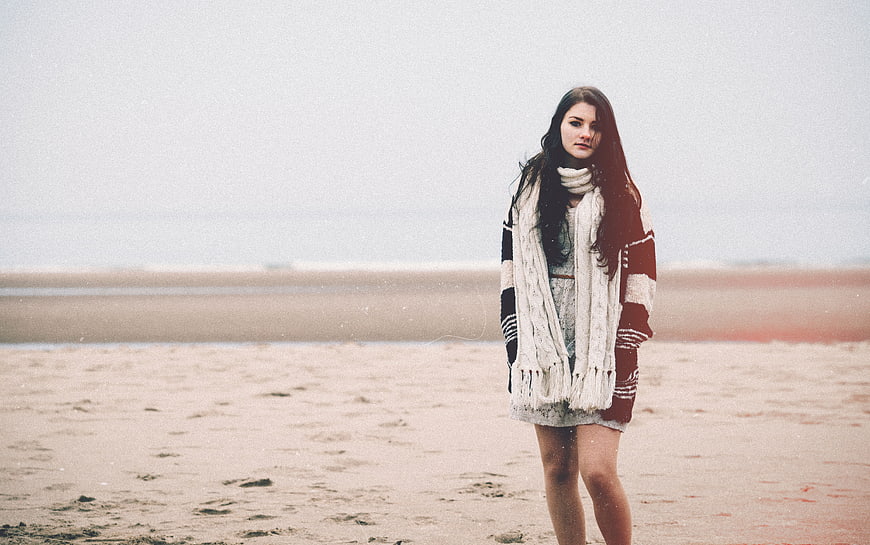 Woman in Knitwear Standing on Sandy Beach