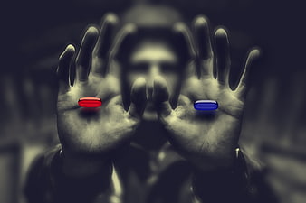 Man holding red and blue pills in hands