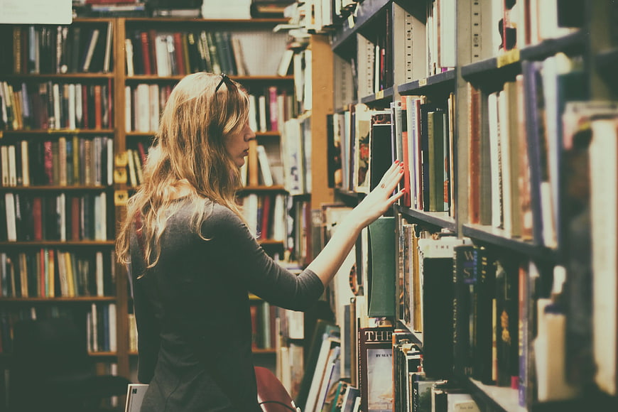 Woman browsing books in a cozy library aisle