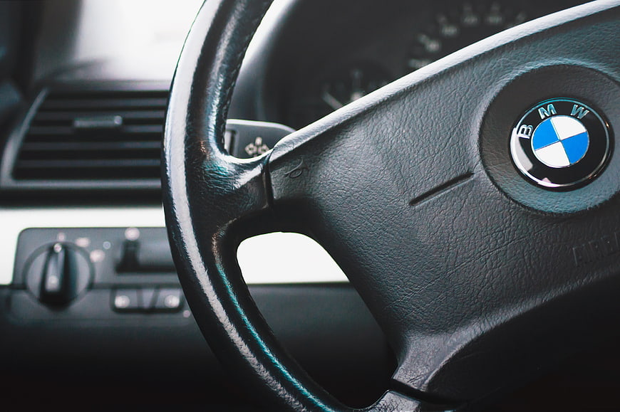 Close-up of BMW steering wheel and car interior dashboard