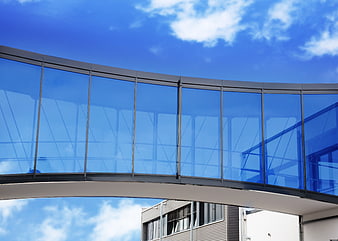 Modern Glass Skybridge Architecture Against Blue Sky