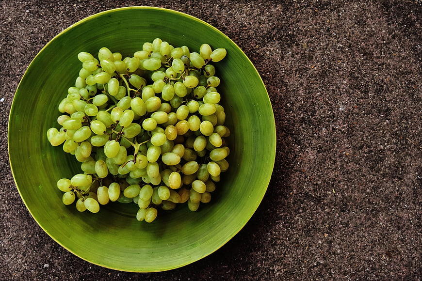 Green Grapes In Green Bowl On Dark Textured Surface