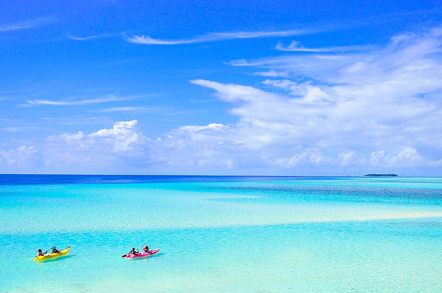 Couples kayaking in turquoise Maldives lagoon