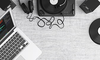 Top view of DJ setup with turntable, laptop, and headphones
