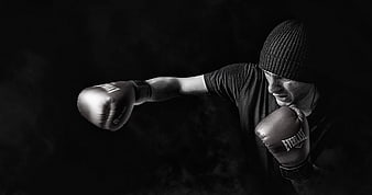 Male boxer punching in black and white with smoke