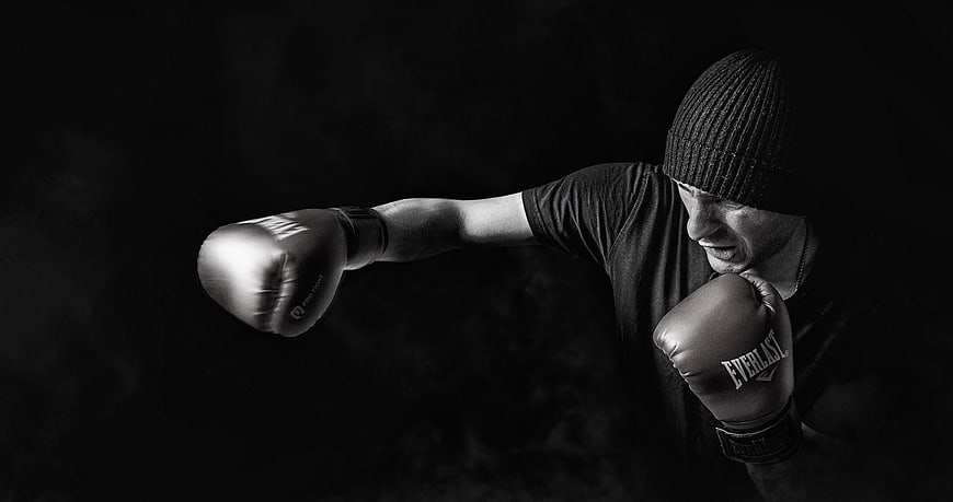 Male boxer punching in black and white with smoke