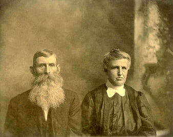 Vintage sepia portrait of elderly bearded couple in historical attire