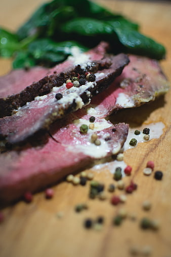 Close-up of sliced rare roast beef with peppercorns