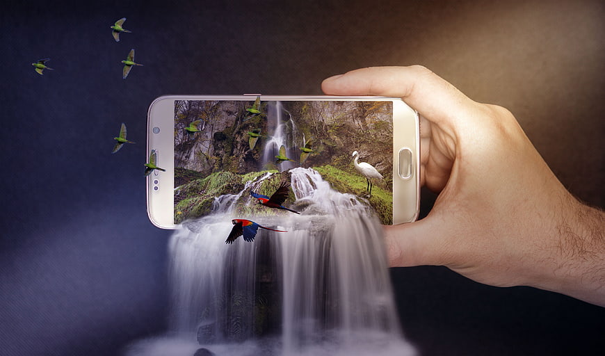 Smartphone with waterfall and birds emerging from screen