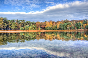 Serene autumn lake with colorful forest reflection