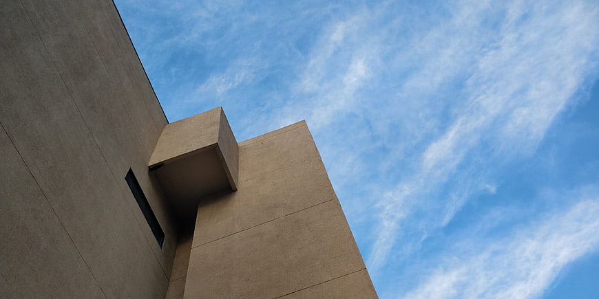 Low angle view of modern concrete architecture against blue sky
