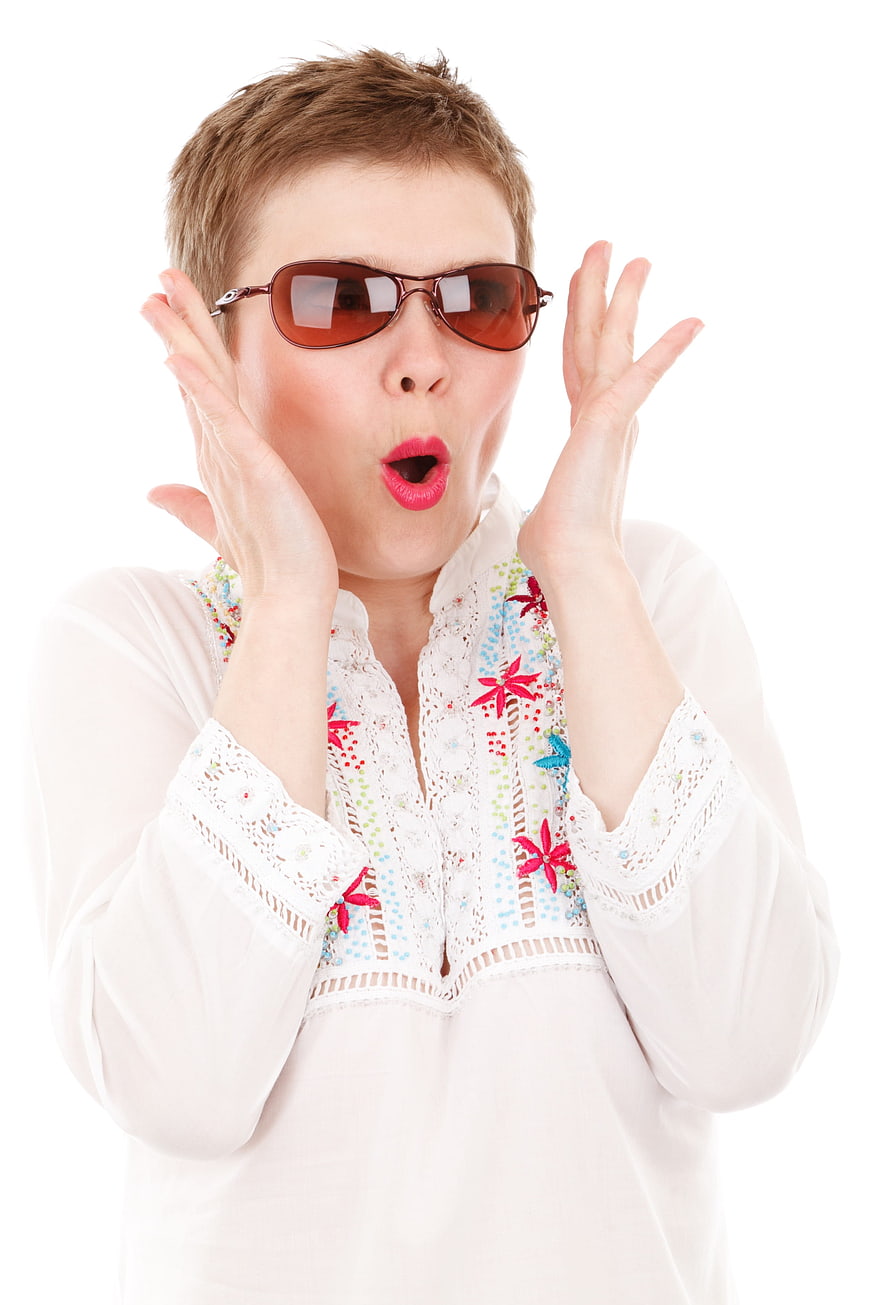 Surprised woman with short hair wearing sunglasses and white blouse