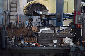Cluttered Auto Repair Shop Workbench with Tools and Car Lift