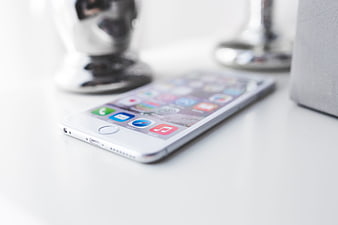 White Smartphone Lying On White Desk With Blurred Background