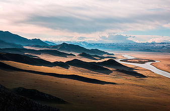 Scenic River Valley with Rolling Hills and Distant Mountains
