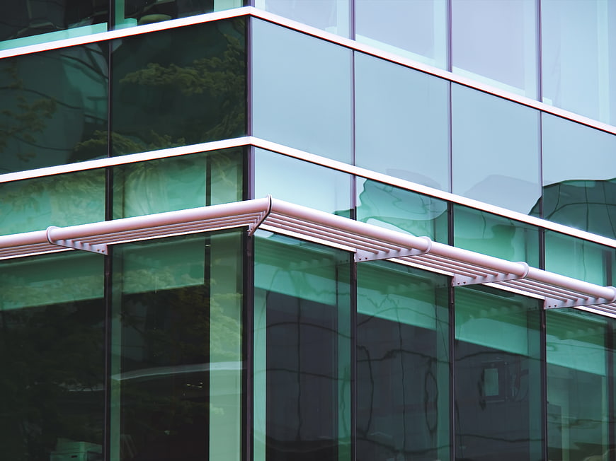Modern Glass Office Building Exterior with Green Reflections