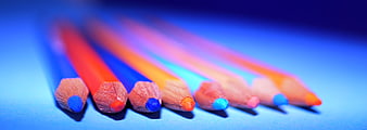 Colorful pencils arranged on a blue background