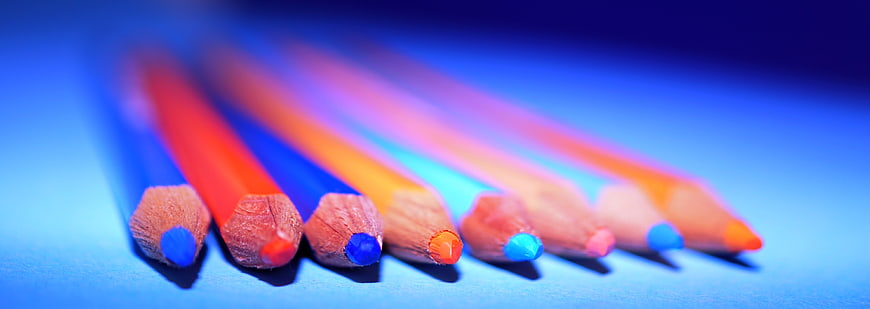 Colorful pencils arranged on a blue background