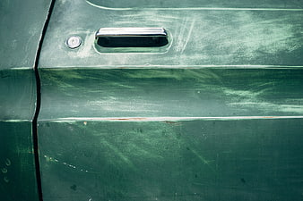 Close-up of vintage green car door with chrome handle