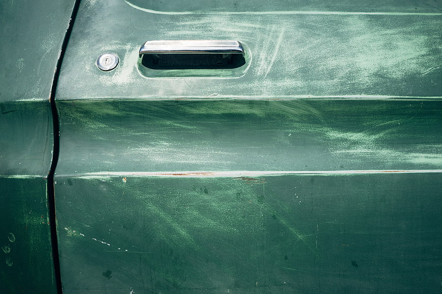 Close-up of vintage green car door with chrome handle