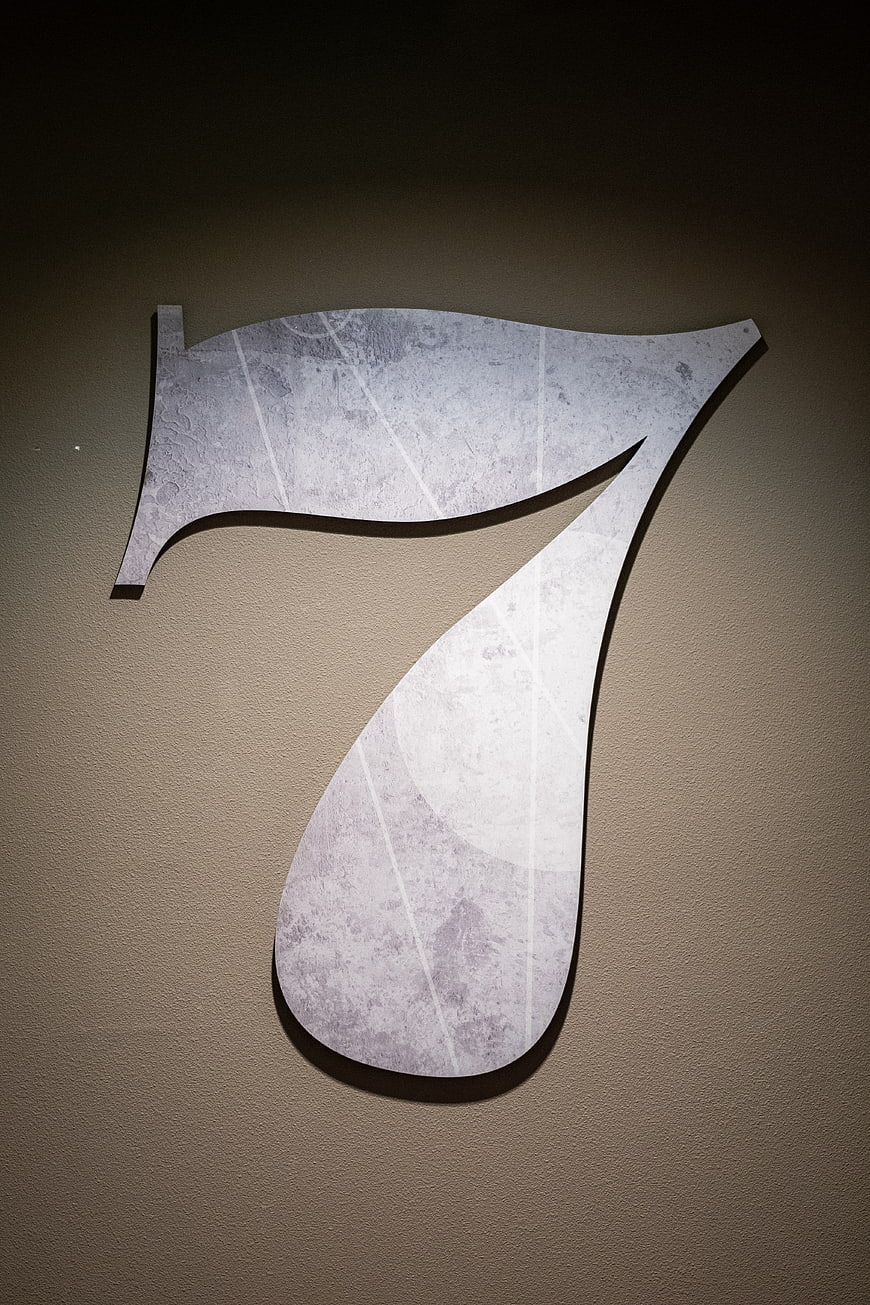 Metallic Number Seven Sign on Textured Wall