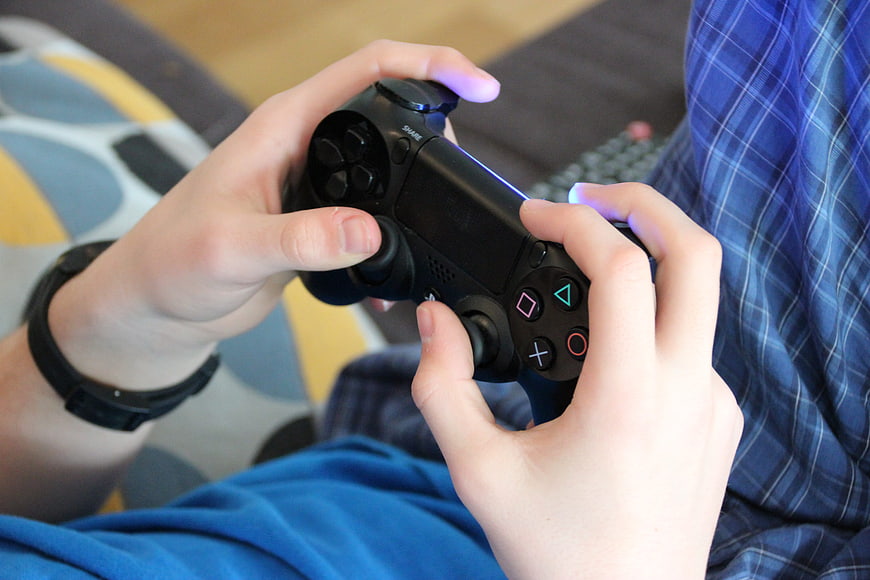 Close-up of hands holding a black video game controller