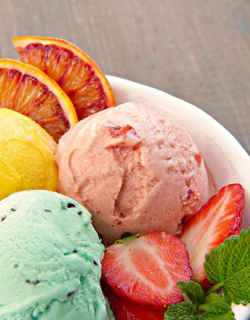 Colorful scoops of fruit ice cream with fresh strawberries and blood orange