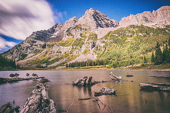 Majestic Mountain Lake with Long Exposure Clouds and Driftwood