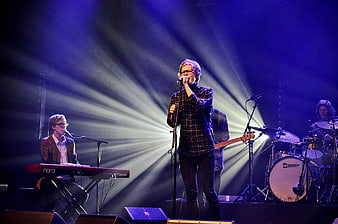 Band performing live on stage with dramatic lighting