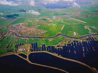 Aerial view of green farmland, river, and coastal water landscape